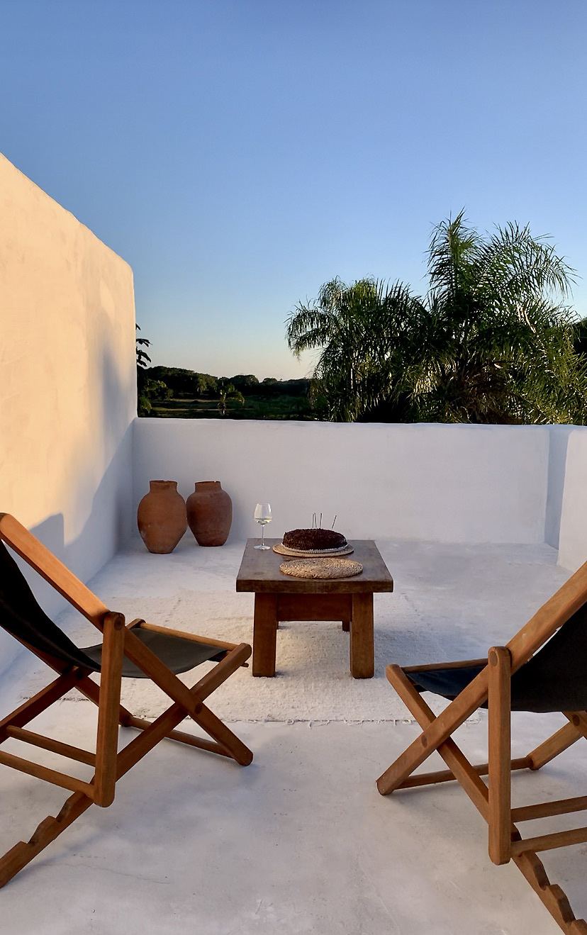 Terraço com cadeiras de lona e mesa de madeira